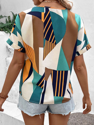 Geometric print V-neck blouse with short rolled sleeves and a multicolor abstract pattern.