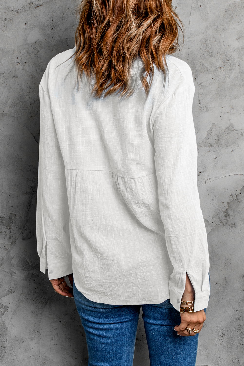 White textured cotton relaxed fit shirt with button cuffs and subtle pleating detail.