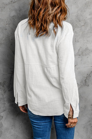 White textured cotton relaxed fit shirt with button cuffs and subtle pleating detail.