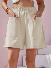 Beige relaxed fit utility shorts with elastic waist and large cargo pockets.