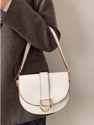 Chic white semi-circular flap crossbody bag with gold hardware and brown trim.