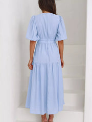 Light blue midi dress with puff sleeves, elastic waist, and tiered skirt.