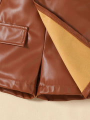 Brown faux leather baby shorts with pocket detail and soft lining.