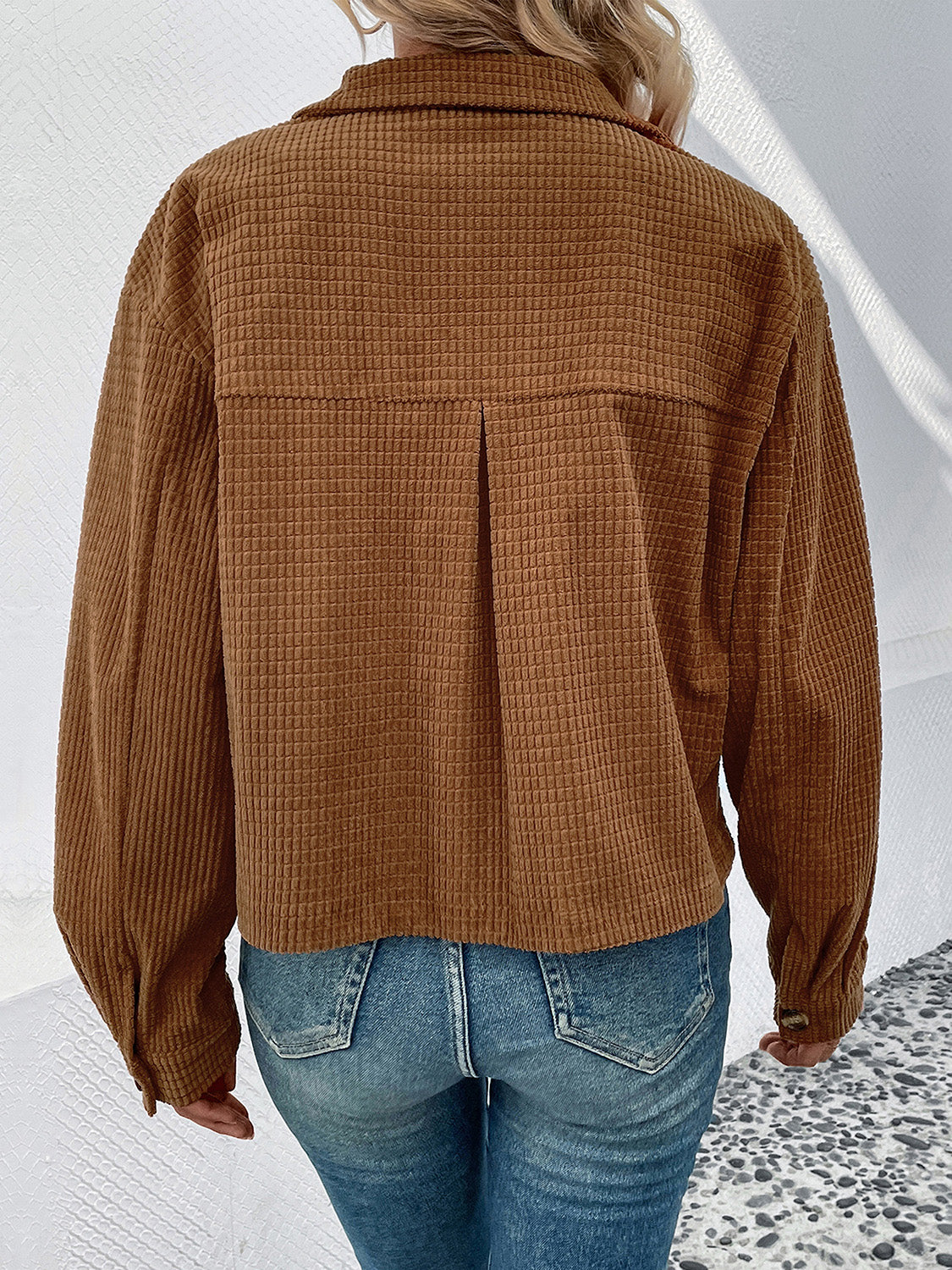 Textured corduroy cropped shirt jacket in camel with button cuffs and a back pleat detail.