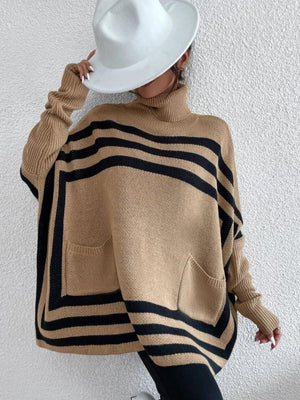 Tan acrylic turtleneck poncho sweater with black geometric stripes and front pockets.