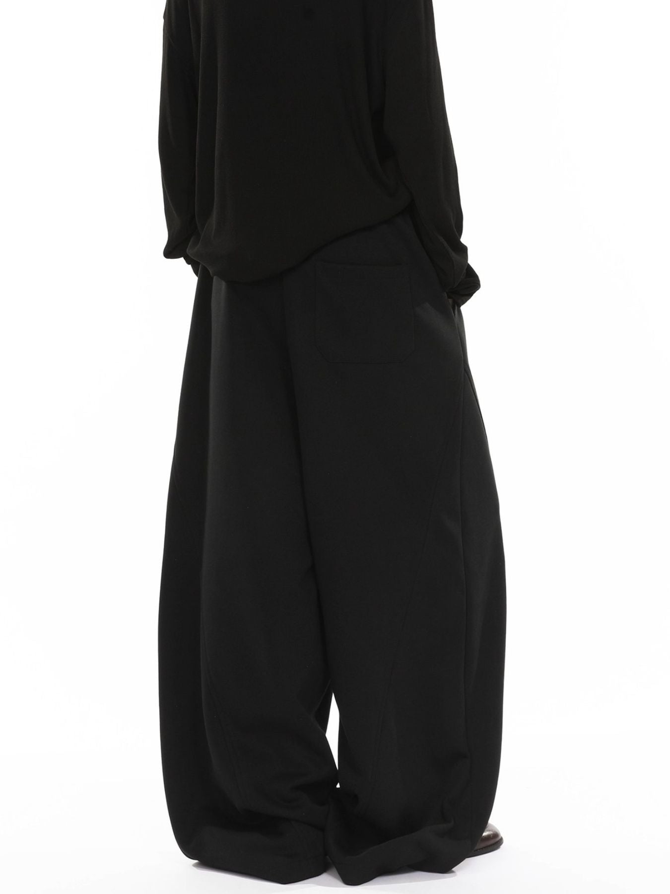 Men's black wide-leg sweatpants with drawstring and back pocket detail.