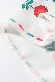 Embroidered medallion peplum blouse in floral print with ruffle detail and white fabric.