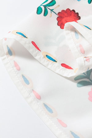 Embroidered medallion peplum blouse in floral print with ruffle detail and white fabric.