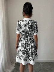 Floral print mini dress with tie belt, short sleeves, and collared neckline.