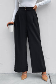 Black high-rise ruched wide-leg trousers with a button closure, styled casually.