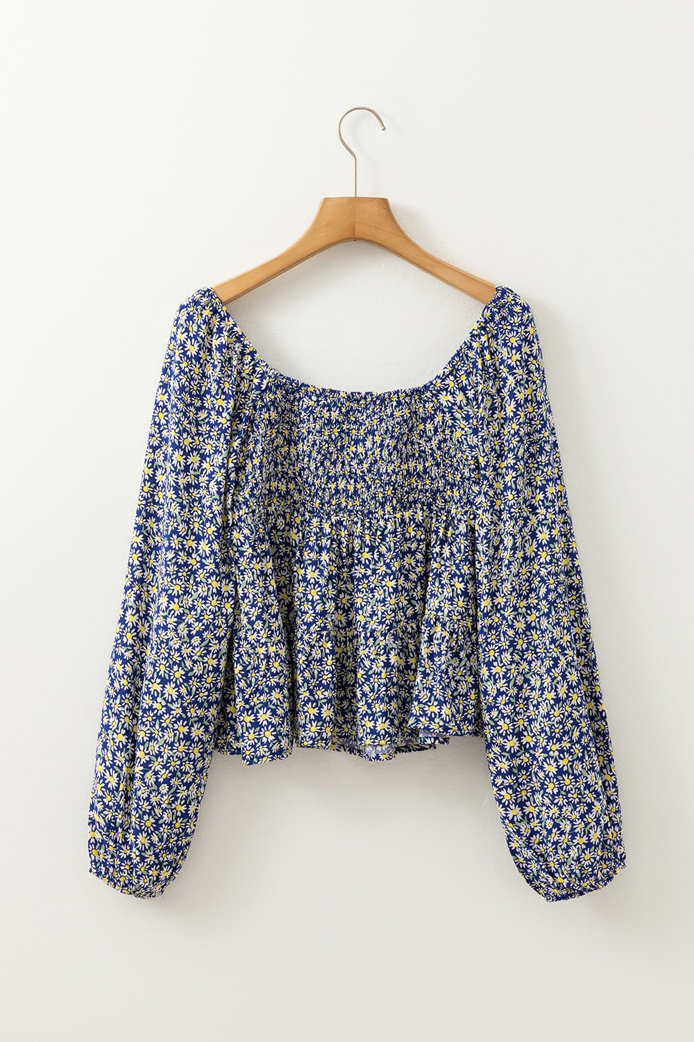 Daisy print smocked peplum blouse in dusty blue 100% viscose with square neckline and long sleeves.