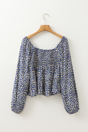 Daisy print smocked peplum blouse in dusty blue 100% viscose with square neckline and long sleeves.