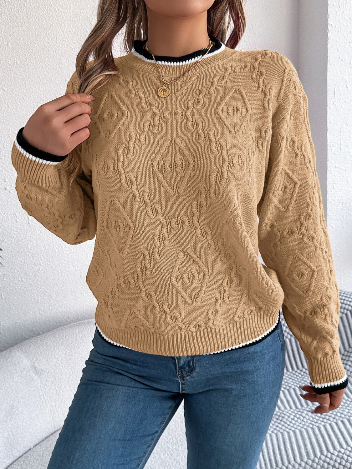 Tan diamond knit sweater with contrast trim neckline and cuffs.