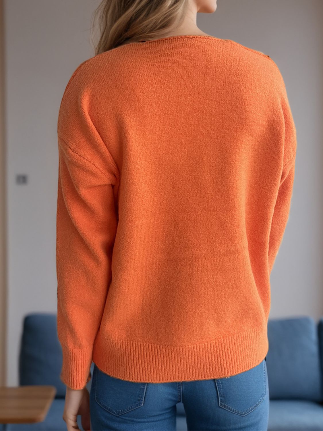 Orange acrylic V-neck sweater with ribbed hem and cuffs, relaxed fit.