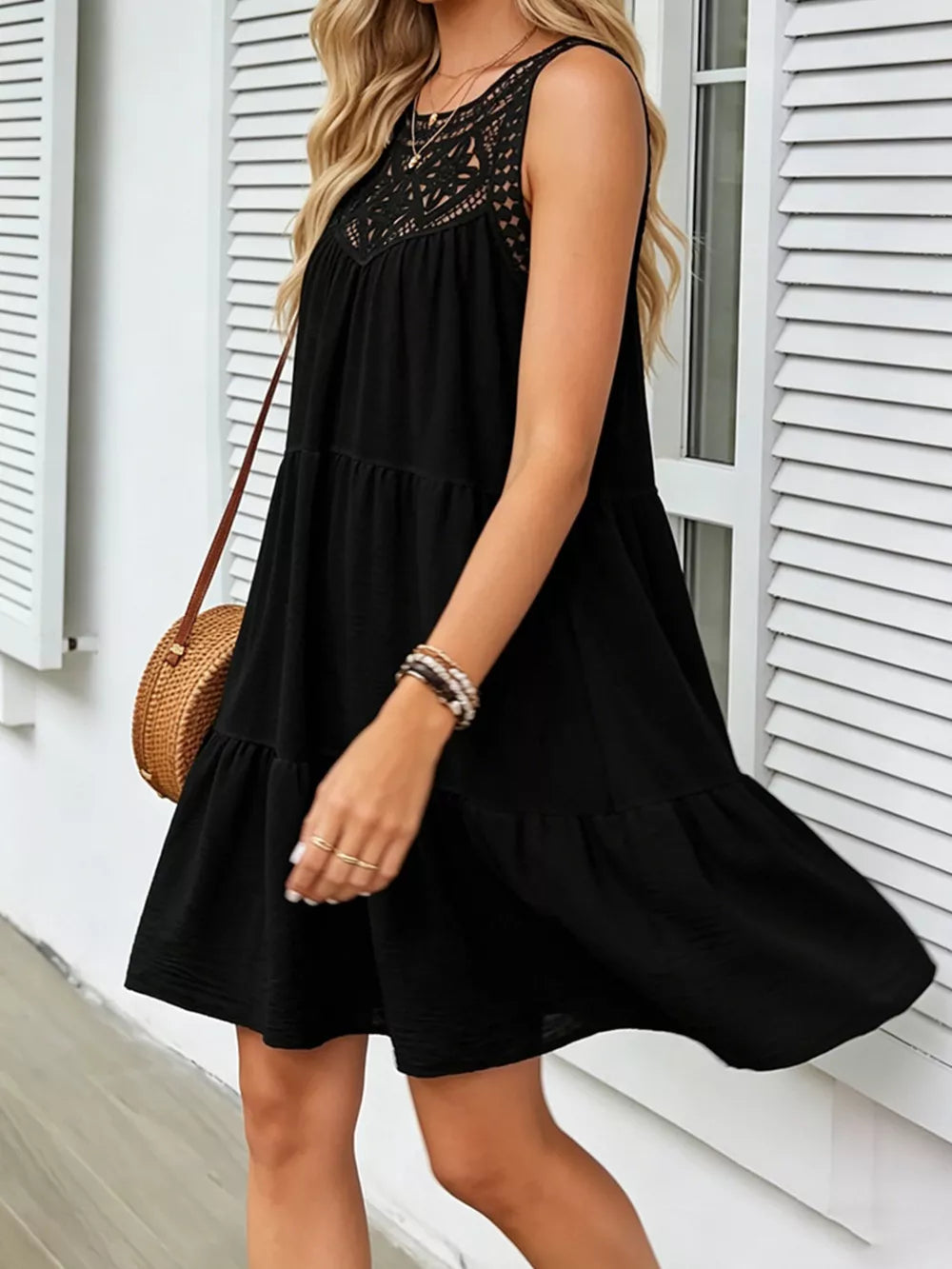Black tiered dress with lace neckline detail, sleeveless, casual mini length.