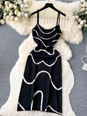Black wavy knit midi dress with spaghetti straps and white abstract pattern.