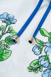 White polyester shirt with blue floral print and tie-neck detail.