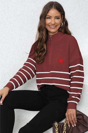 Burgundy knit sweater with white stripes, zip neck, and red heart patch detail.