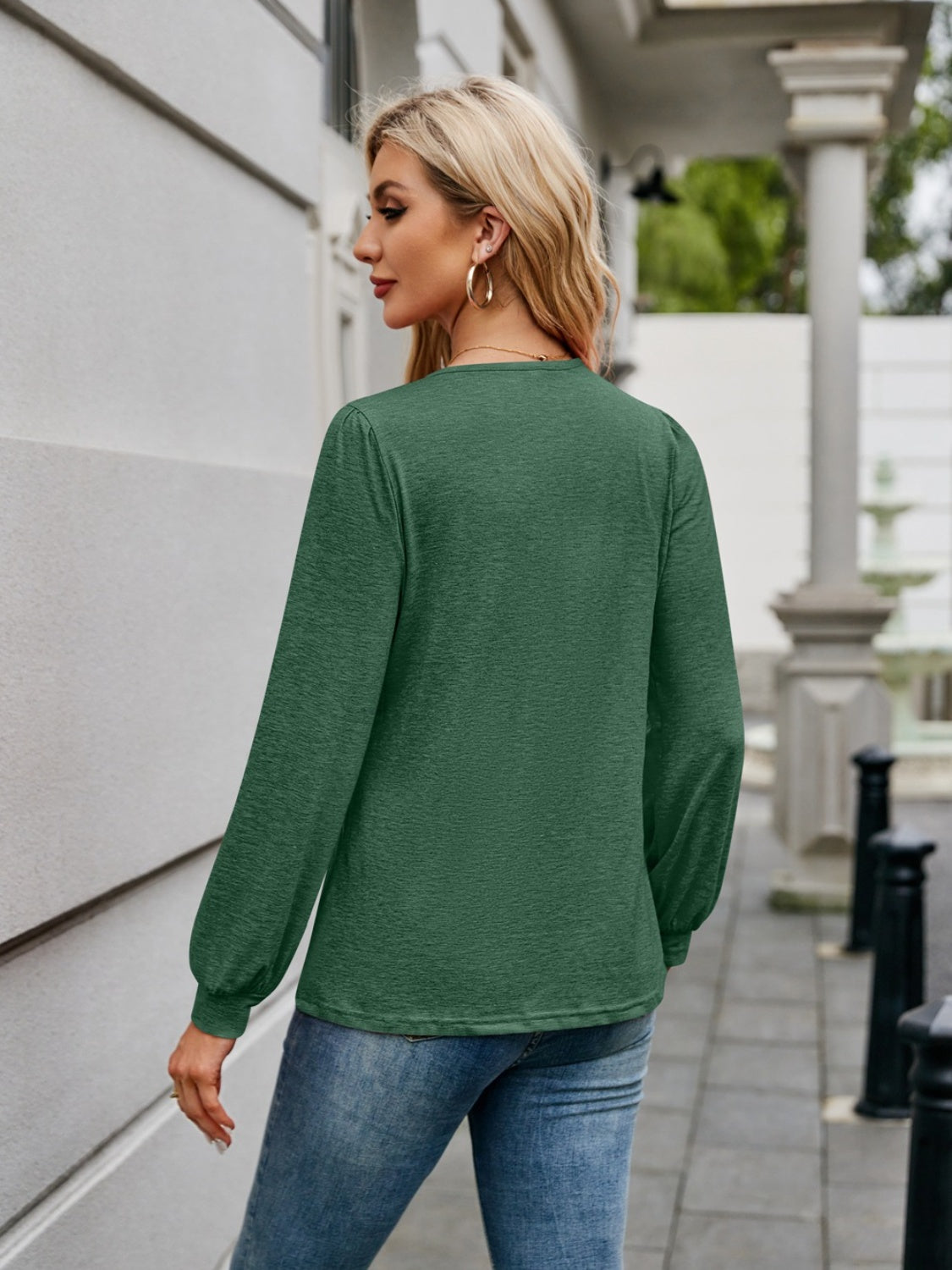Dark green long sleeve blouse with gathered sleeves and a subtle texture.