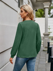 Dark green long sleeve blouse with gathered sleeves and a subtle texture.