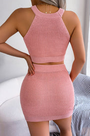 Peach knit halter crop top and mini skirt set with ribbed texture and gold heart necklace detail.