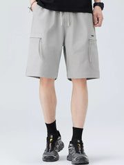 Men's light gray cargo shorts with zippered pockets and drawstring waist.