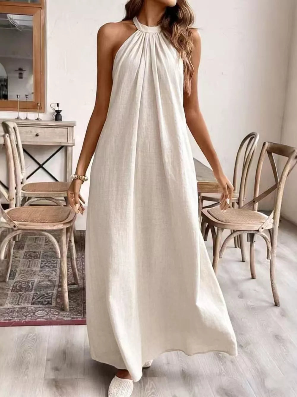 Cream white ruched halter maxi gown with gathered neckline and flowing skirt.