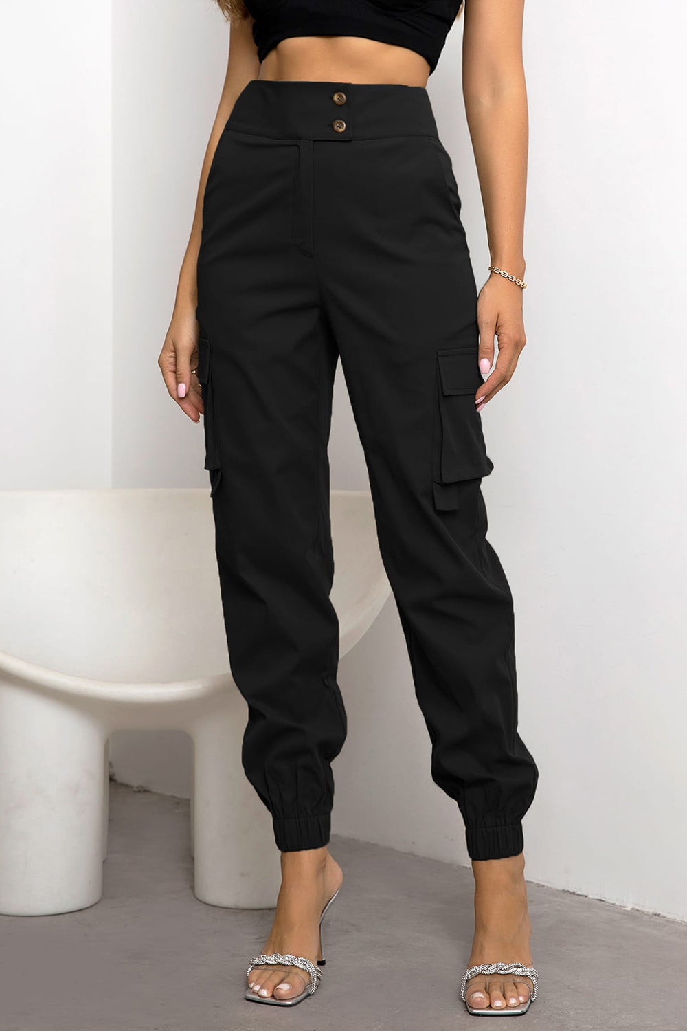 Black cargo jogger trousers with button detail and elasticated cuffs.