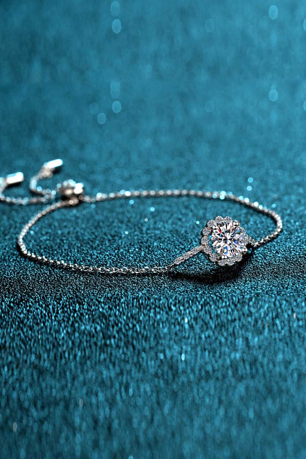Silver adjustable bracelet with a round, sparkling gemstone centerpiece surrounded by smaller stones.
