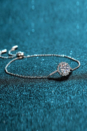 Silver adjustable bracelet with a round, sparkling gemstone centerpiece surrounded by smaller stones.