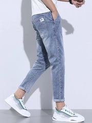 Light blue washed skinny jeans with cuffed ankles and adjustable drawstring detail.