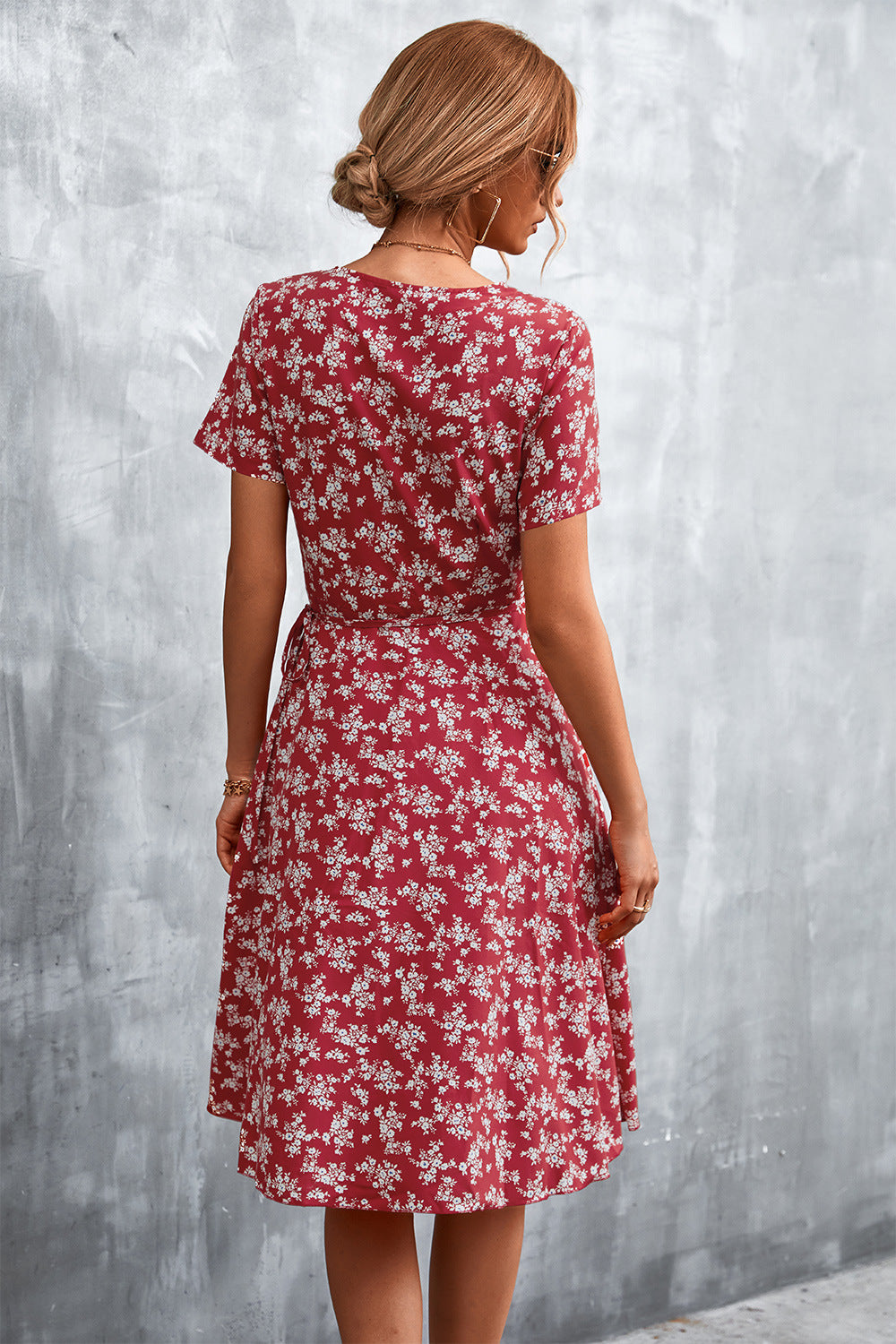 Crimson floral wrap midi dress with short sleeves and a tie waist.