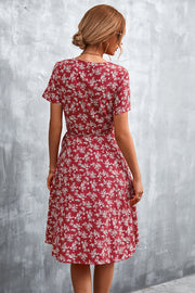 Crimson floral wrap midi dress with short sleeves and a tie waist.