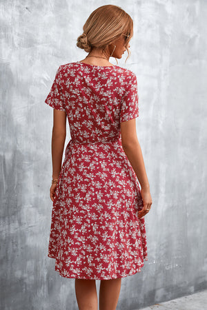 Crimson floral wrap midi dress with short sleeves and a tie waist.