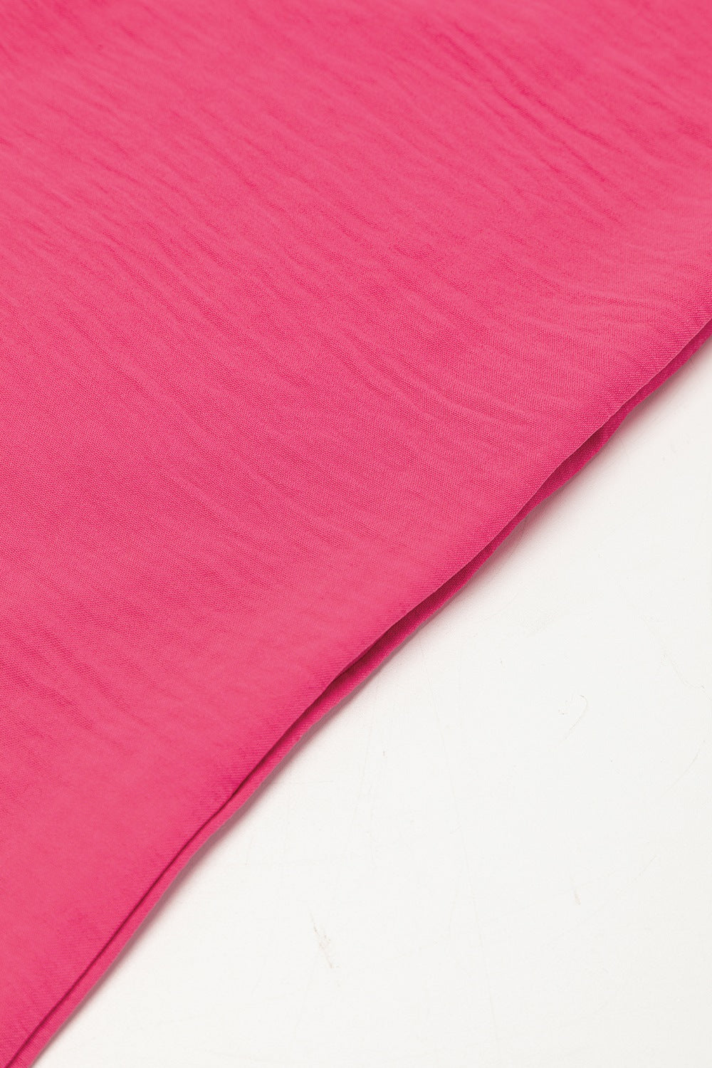 Oversized shirt romper in hot pink with textured fabric detail.