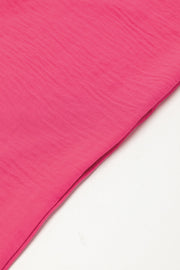Oversized shirt romper in hot pink with textured fabric detail.