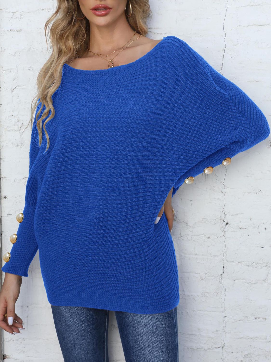 Royal blue batwing knit sweater with pearl button details on the sleeves.