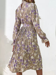 Elegant floral midi dress in khaki with purple roses, long sleeves, pleated skirt, and tie waist.
