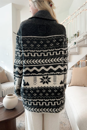 Black geometric jacquard wrap cardigan with shawl collar and belt detail.