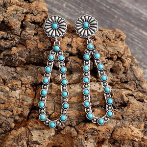 Silver floral turquoise bead drop earrings with a teardrop shape and detailed metalwork.