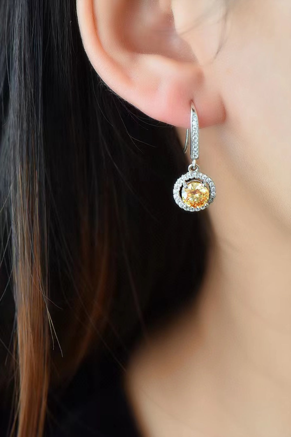Golden halo moissanite drop earrings with yellow center stone and white diamond accents.