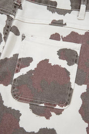 Cow print utility jeans with a visible cargo pocket detail.