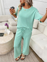 Light green loungewear set with crew neck top and drawstring pants, white piping detail