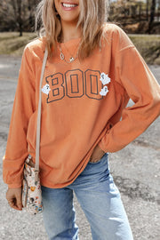Corduroy sweatshirt in sherbet orange with "Boo" appliqué and ghost details.