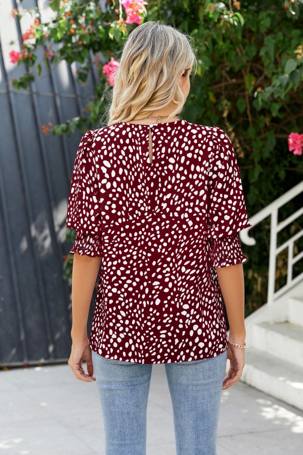 Burgundy blouse with white spot print, shirred short sleeves, and keyhole back detail.