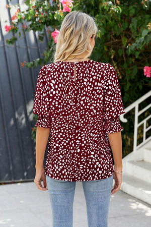 Burgundy blouse with white spot print, shirred short sleeves, and keyhole back detail.