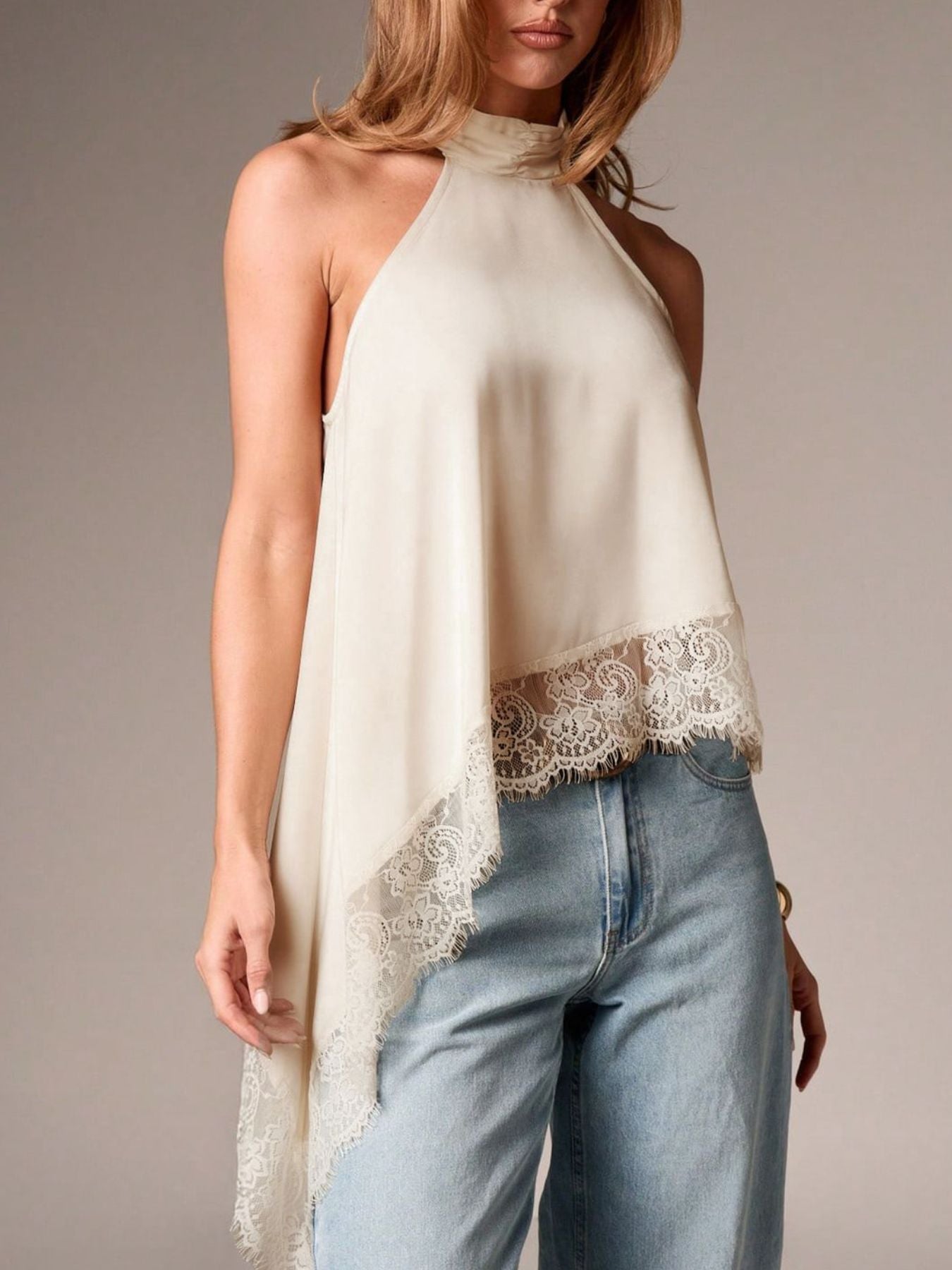 Beige halter camisole with lace trim and asymmetrical hem.