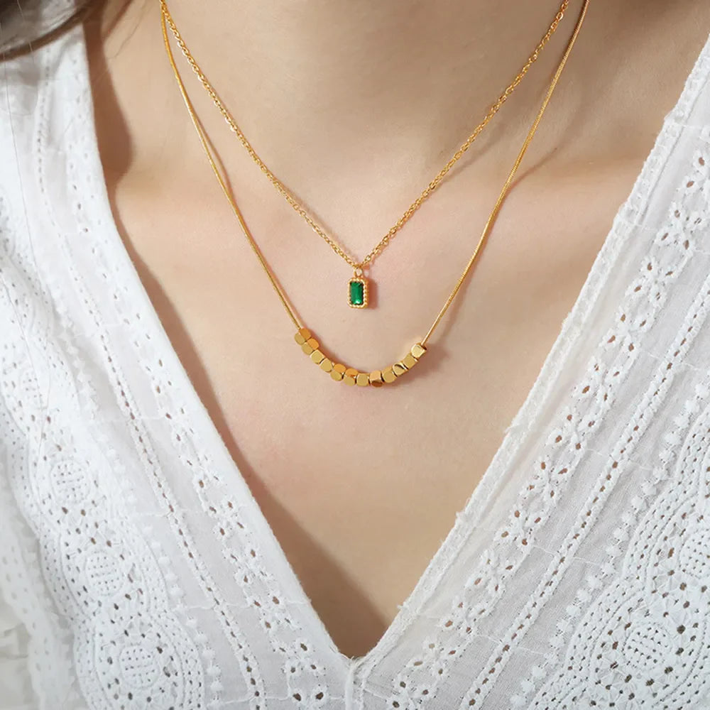 Gold layered necklace with emerald cube and cube beads