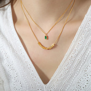 Gold layered necklace with emerald cube and cube beads
