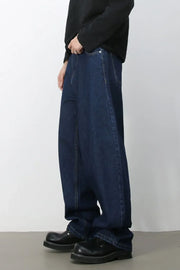 Faded baggy denim jeans in dark blue, styled with a black top and chunky shoes.
